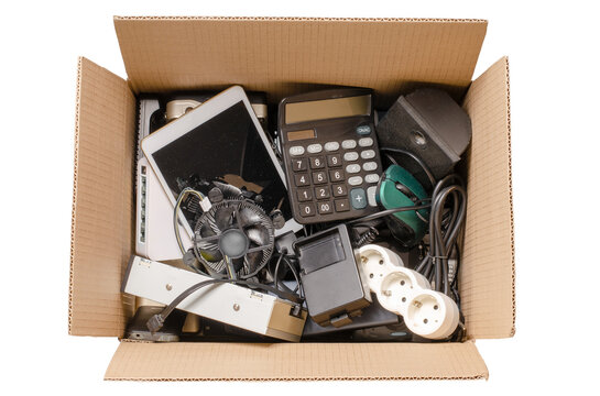 Old electronic devices in a cardboard box. The concept of recycling used gadgets. Isolated on white