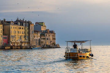 Boats and the old town of Rovinj, Croatia in sunset light in summer.