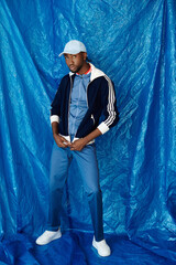 Charming young man posing confidently against a vibrant blue backdrop