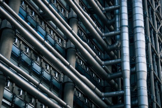 The iconic pipework and exterior of the Lloyds building in the City of London. It is a detail shot of the building's high-tech architecture.