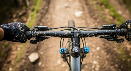 First person view of hands on handlebars of a mountain bike on a dirt trail