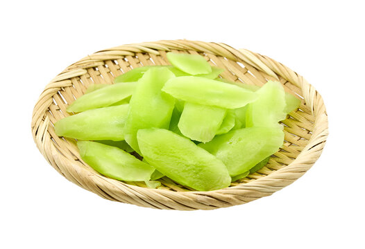 closeup pile of green slice cut wosun or celtuce stem lettuce cutout in bamboo wood plate