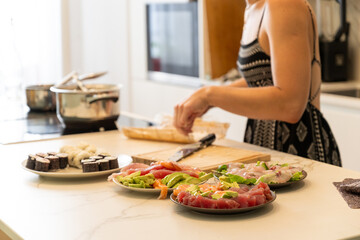 Homemade Sushi Preparation with Fresh Ingredients by Woman in Modern Kitchen Setting