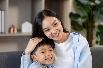 Obraz premium Joyful Moment. A mother and her son sharing a happy smile on the couch.