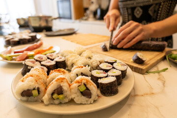 Close-Up of Homemade Sushi Rolls with Fresh Ingredients and sashimi on a Marble Counter