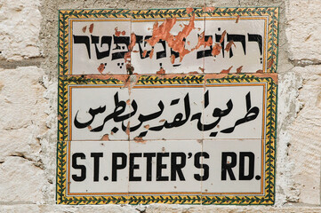 Fototapeta premium White, tiled road sign marking the St. Peter's Road in the Christian Quarter of the Old City of Jerusalem, Israel