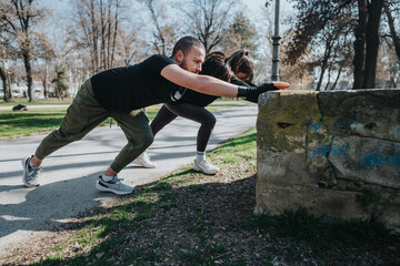 Teenagers engaging in an outdoor workout activity, pushing against a structure in a park. Scene...