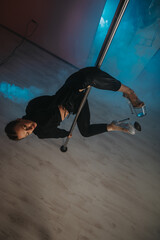 A woman practicing a creative and athletic pole dance routine, highlighting physical skill and...