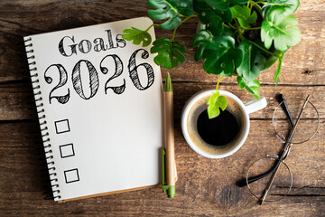 New year goals 2026 on desk. 2026 resolutions list with notebook, coffee cup on table. Goals,...