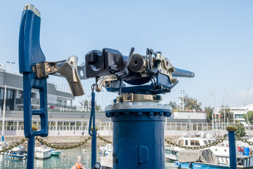 Jardine Noonday Gun in Hong Kong: A vintage naval cannon, painted blue and brass, is mounted on a...