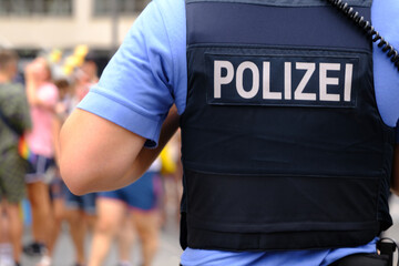 German police officer on duty in public place, uniformed policeman patrolling streets, public...