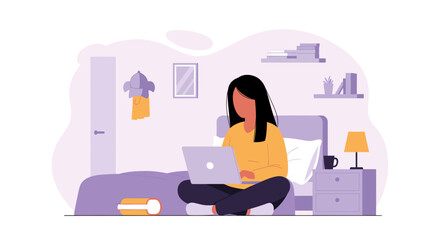 Young woman comfortably working on her laptop computer while sitting cross-legged on her bed.