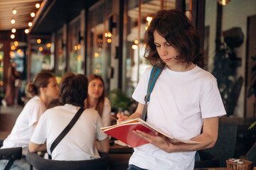 Standing in front of people. Group of young friends are in the cafe restaurant