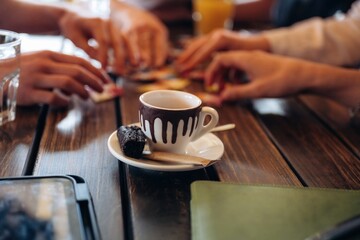 Close up view of young people sitting by the table indoors