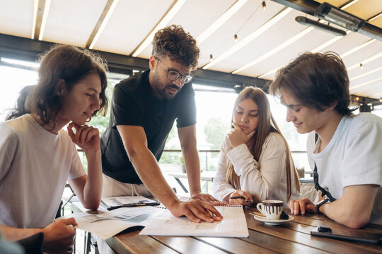 Cool start up, working on the project. Group of young friends are in the cafe restaurant