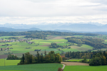 One beautiful landscape the summer day in Switzerland. Green European valley with mountains on the background with cloudy sky