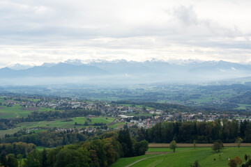 Beautiful landscape the summer day in Switzerland. Green European valley with mountains on the background with cloudy sky