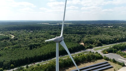 Aerial drone view of wind turbine energy generation electricity and verdant green rural forest...