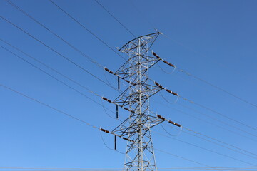 High voltage electrical transmission lines against a blue sky