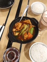 A Hearty Bowl of Braised Tofu and Vegetables with Rice and a Drink