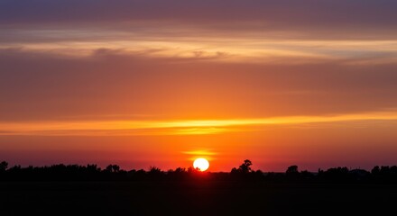 Vibrant sunset with vivid orange and purple sky over dark horizon