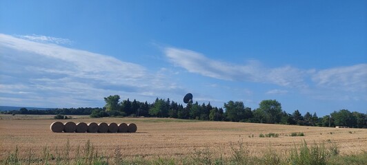 landscape with trees, straw bales and clouds