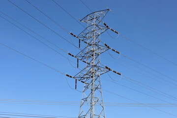 High voltage electrical transmission lines against a blue sky