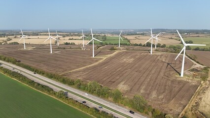 Aerial drone view of wind turbine power plants renewable energy electricity with rural English...