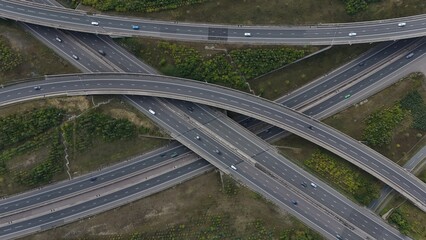 Aerial drone shot of busy motorway junction intersection with numerous bridges and lanes and vehicles near Rugby England UK M1 highway 