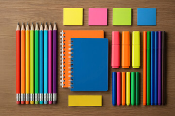 Fototapeta premium Top view of neatly arranged colorful school supplies including pencils, notebooks and markers on table