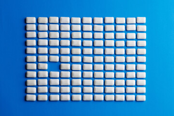 White mint gum rectangle with missing center piece on blue background
