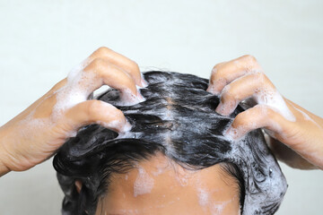 A woman takes a shower and washes her hair in the bathroom at home.