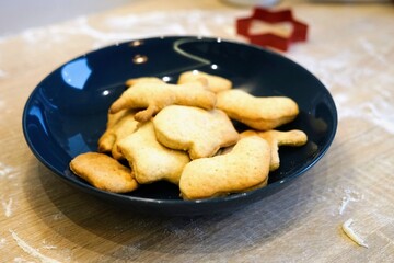 homemade Christmas cookies in blue plate on wooden table flour New Year mould celebrate family atmosphere holiday 