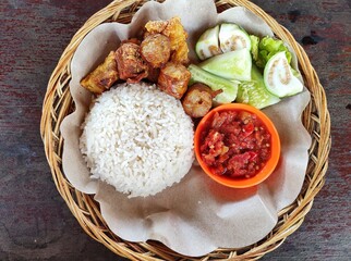 Balinese rice, a typical Balinese food consisting of rice, roast pork, fried pork, lettuce,...