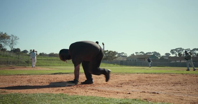 Batter hitting grounder forcing runner diving into first, male fielders making play at first base