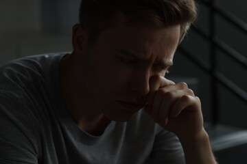 Sad man crying alone in darkness. Depression