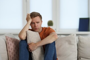 Sad thoughtful man on sofa at home