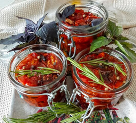 Jars of fiery, herb-infused tomato conserve evoke rustic Italian autumn, echoing the spirit of La...