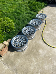 Sunlit alloy wheels gleam like urban halos on concrete, echoing Earth Day's sustainability spark...