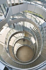 Fototapeta premium An aerial shot of a spiral staircase in a modern building, looking straight down to create a hypnotic geometric pattern.