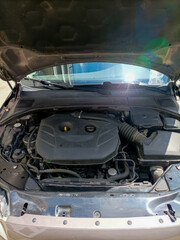 Car engine bay basks in radiant sunlight, epitomizing mechanical harmony, invoking National Mechanics Week and World Engineers Day celebrations