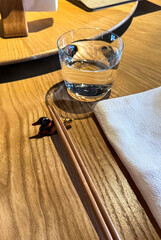 Serene glass of water casting shadows beside a poised napkin, evoking Zen mindfulness and World Water Day tranquility
