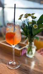 Chilled orange spritz beside daisies whispers summer solstice serenity and International Cocktail Day whimsy, refreshing urban retreat