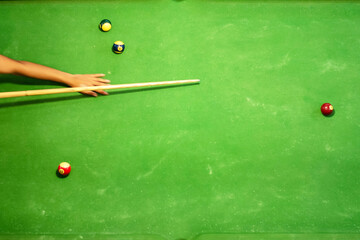 Plays billiard or pool in club. playing billiard cue strikes the ball on table.