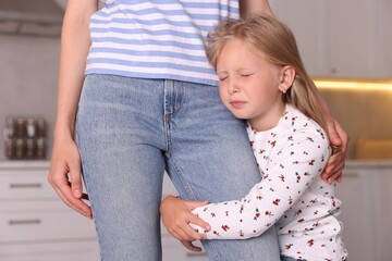 Little girl afraid to leave without mother and hugging her at home. Separation anxiety