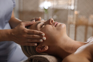 Beautiful woman receiving facial massage in spa salon, closeup