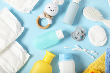Baby accessories and cosmetic products on light blue background, flat lay