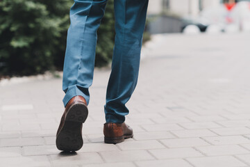 Man in blue suit walking on an urban street, representing professionalism, confidence, and style...