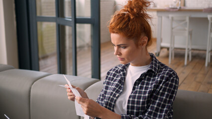 Unhappy Caucasian shock woman female girl buyer client customer hold long grocery receipt checks...