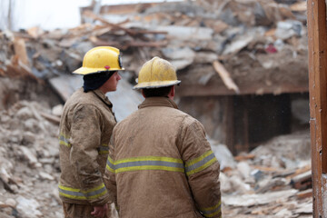 Firefighters inspecting rubble after building collapse